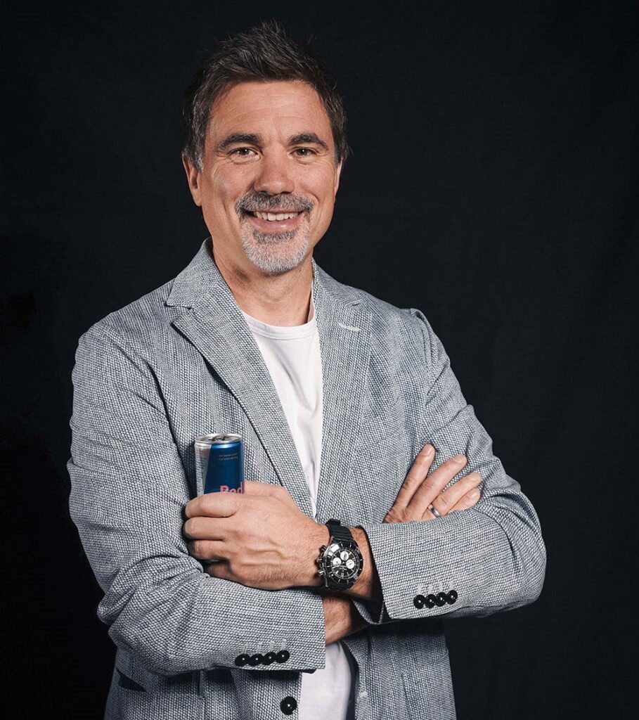 Strategischer Coach Patrick Murnig freundlich lächelnd mit verschränkten Armen und einer Red Bull Dose.